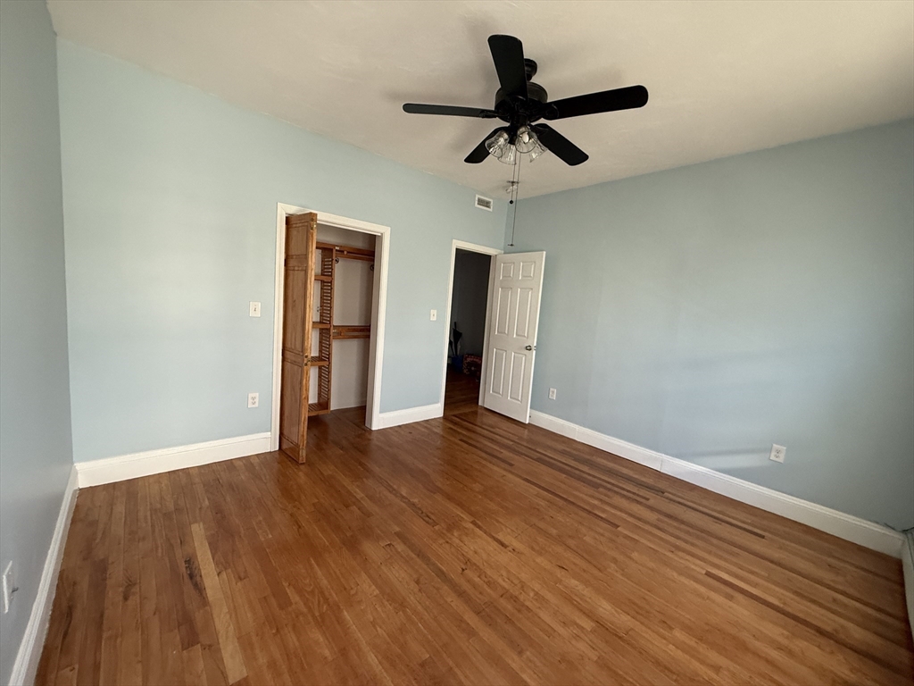 55 Lithgow Street, Unit 3 Boston, MA 02124 - Photo 15 of 16 a view of empty room with wooden floor and ceiling fan
