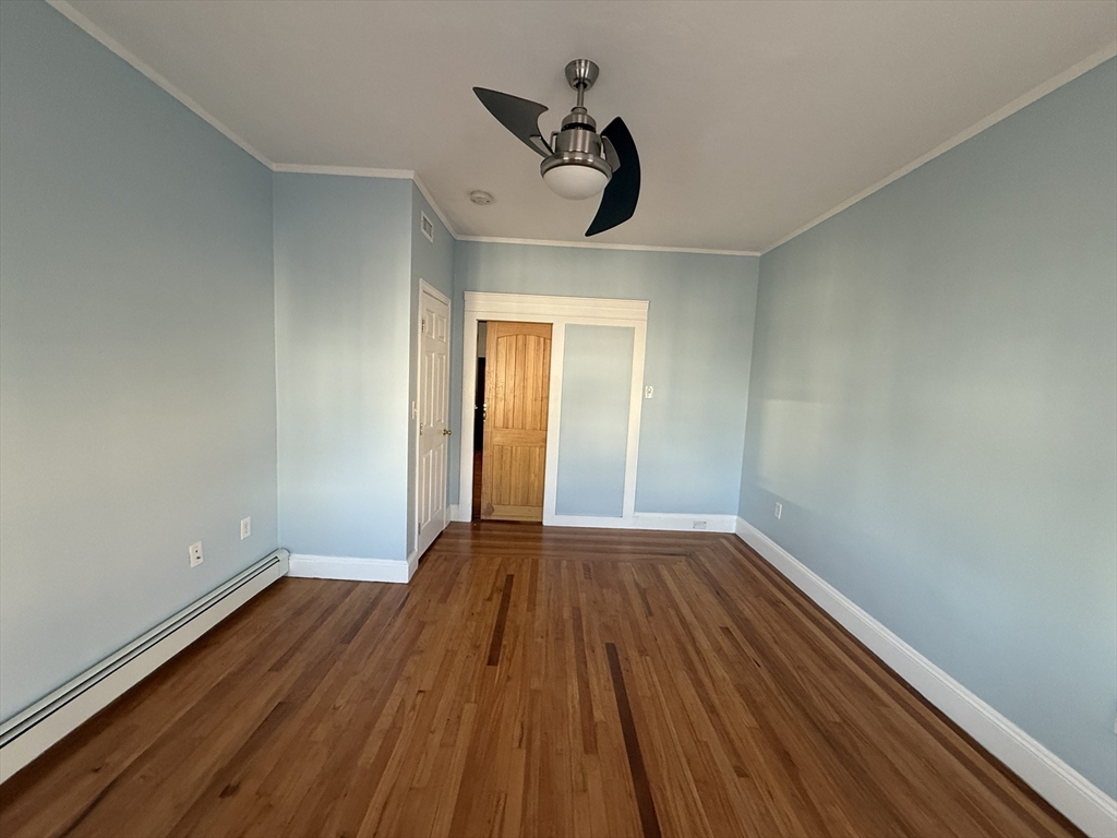 55 Lithgow Street, Unit 3 Boston, MA 02124 - Photo 4 of 16 a view of empty room with wooden floor and fan