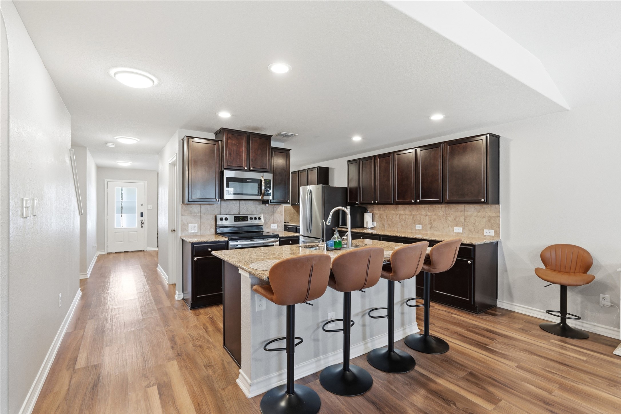 2811 Davis Trace San Antonio, TX 78245 - Photo 8 of 31 a kitchen with stainless steel appliances granite countertop a stove top oven a sink dishwasher and a refrigerator with wooden floor