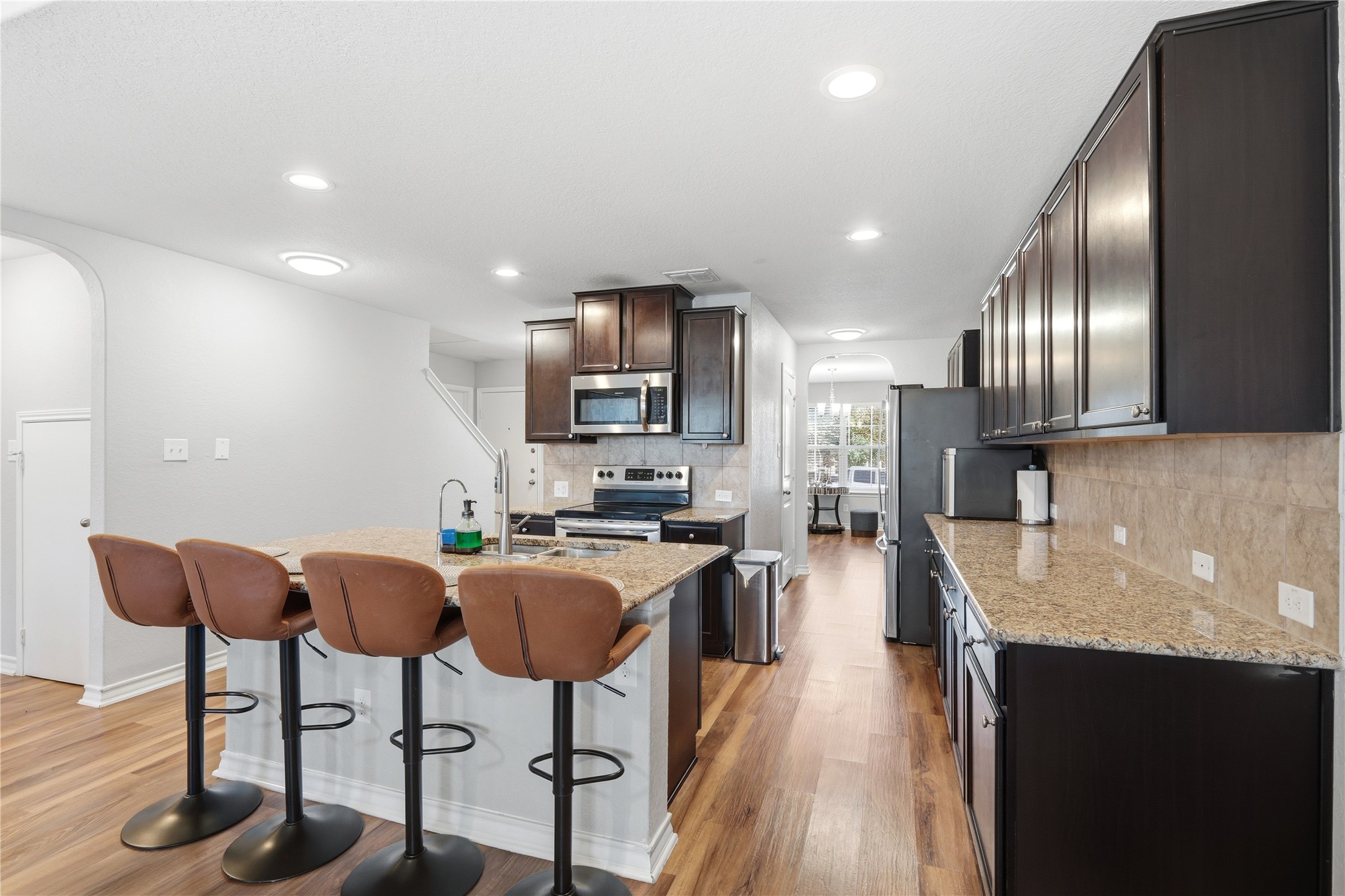2811 Davis Trace San Antonio, TX 78245 - Photo 9 of 31 a kitchen with stainless steel appliances granite countertop a stove top oven a sink dishwasher a dining table and chairs with wooden floor
