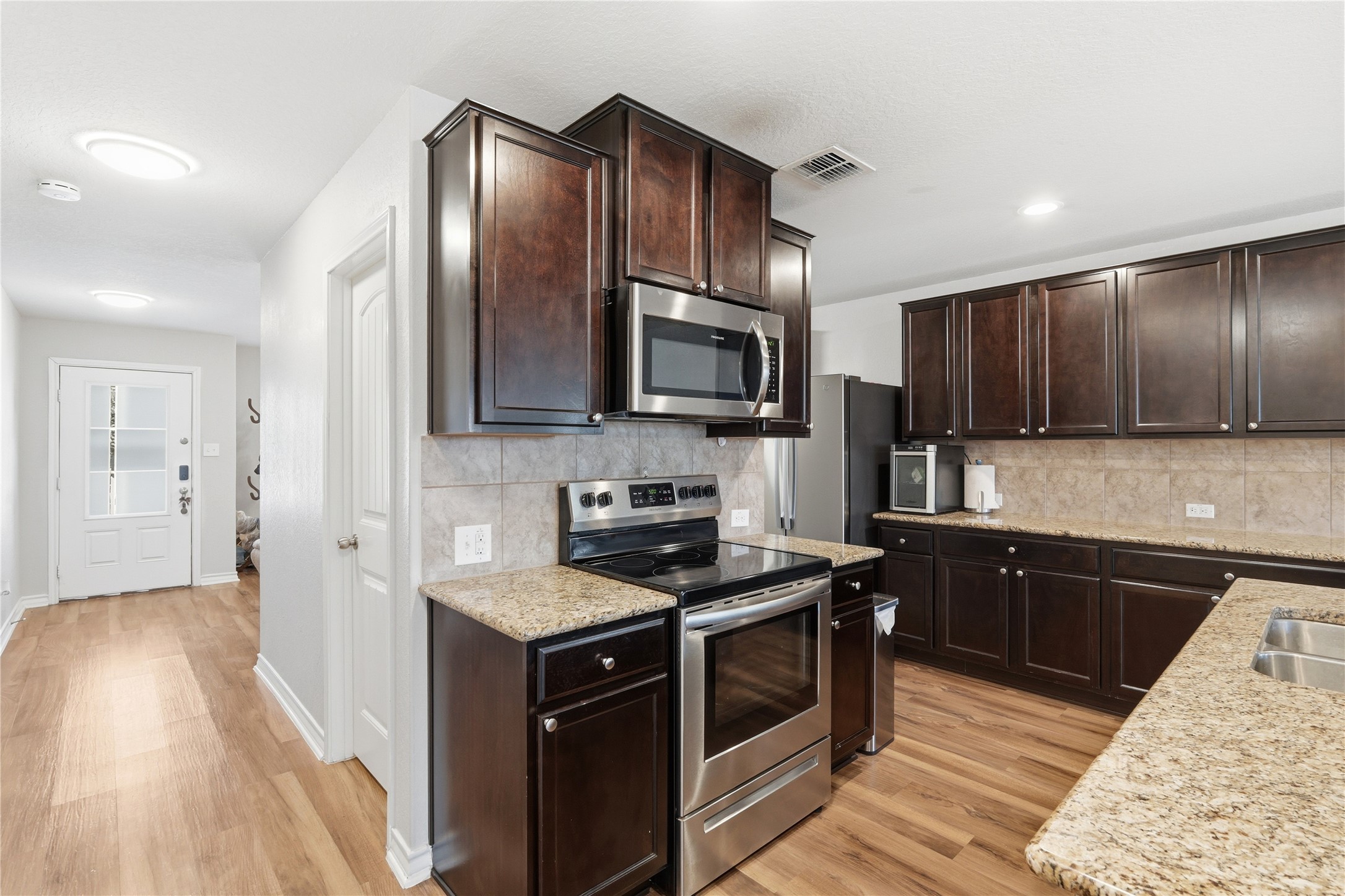 2811 Davis Trace San Antonio, TX 78245 - Photo 10 of 31 a kitchen with granite countertop stainless steel appliances and wooden cabinets
