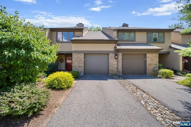 front view of a house with a yard and a garage