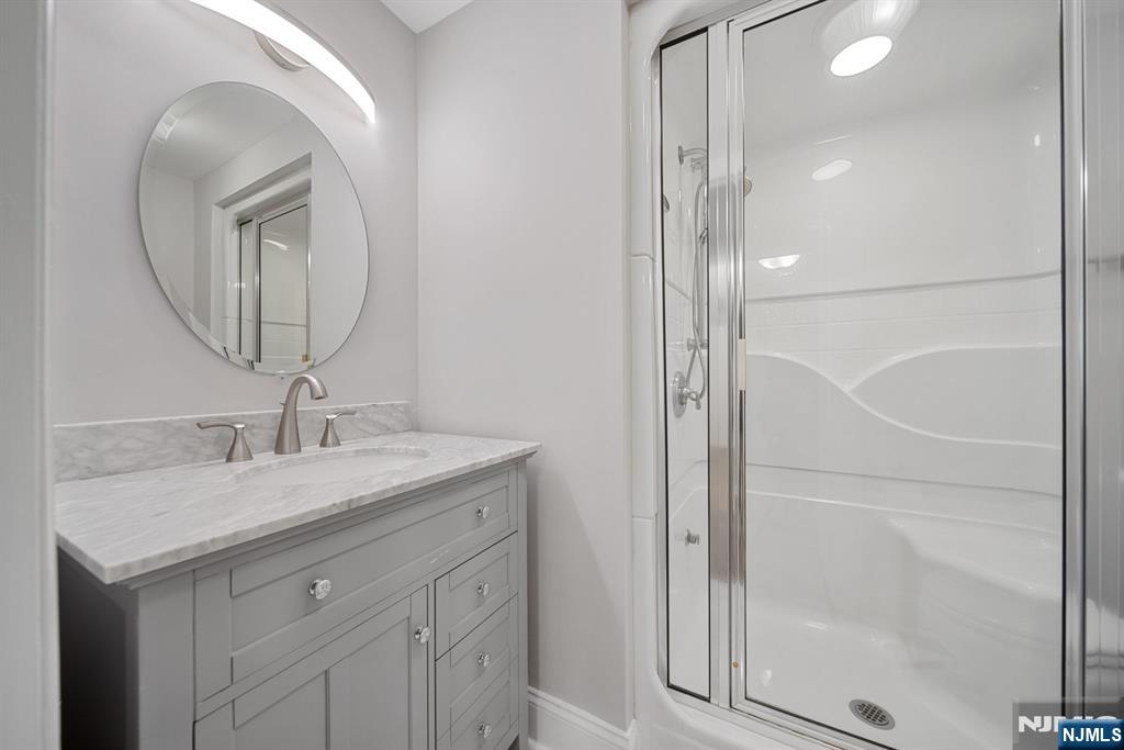 12 Sandburg Court Mahwah, NJ 07430 - Photo 19 of 33 a bathroom with a granite countertop sink a mirror and a shower