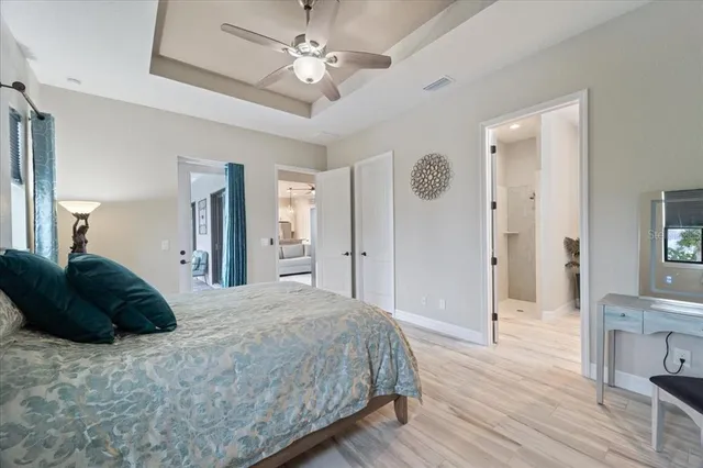 a spacious bedroom with a bed and a chandelier