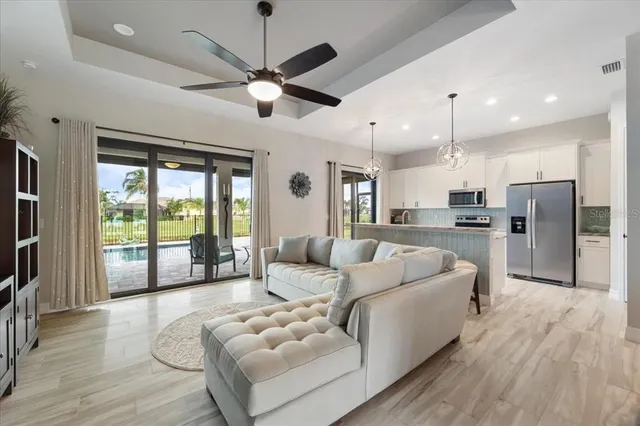a living room with furniture a ceiling fan and a flat screen tv