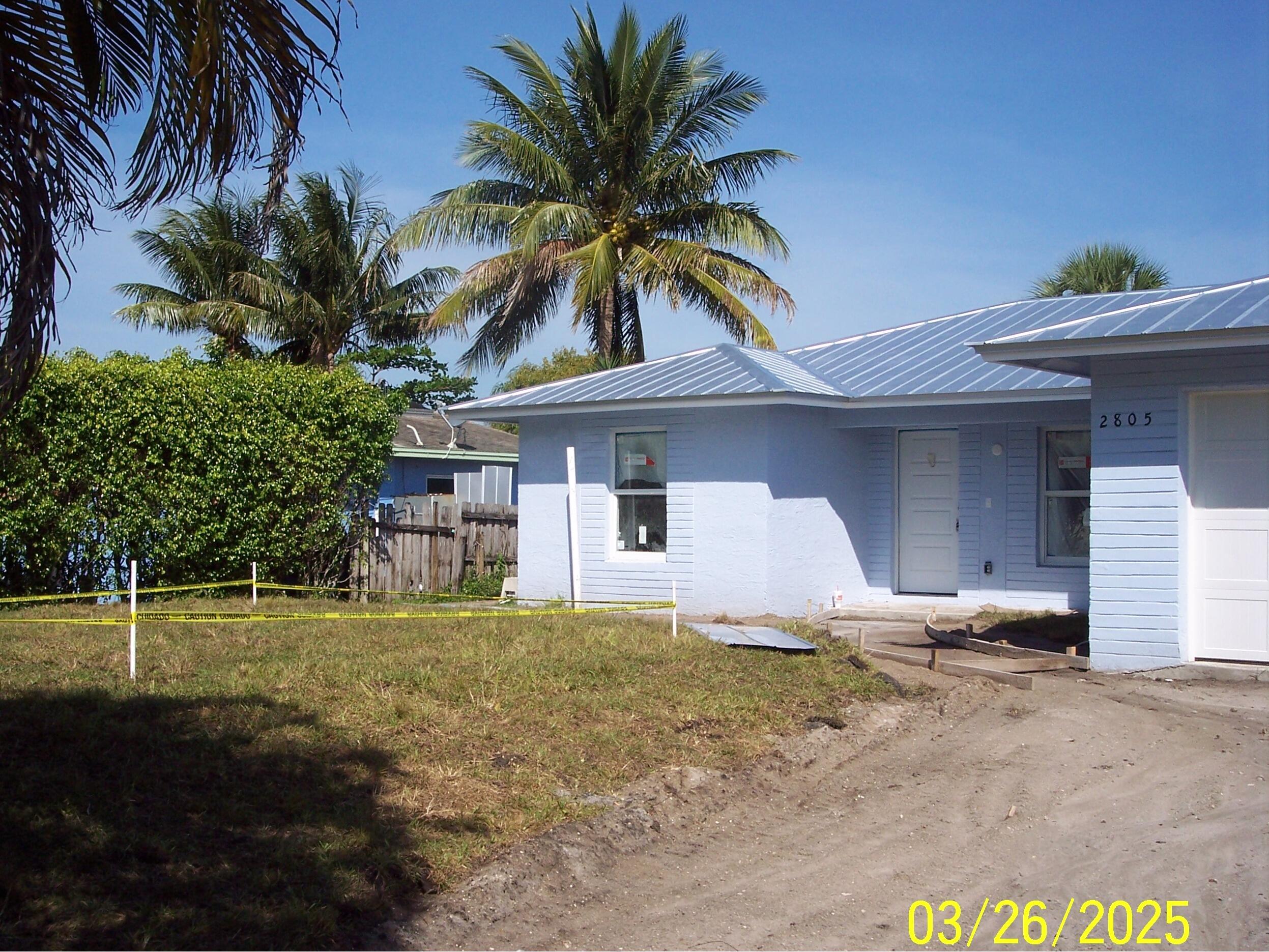 2805 Southeast Carroll Street Stuart, FL 34997 - Photo 3 of 10 a front view of a house with a yard and garage
