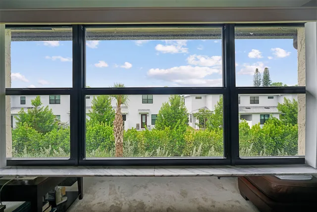 a view of a room that has a large window and front door