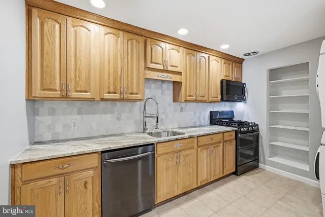 a kitchen with stainless steel appliances granite countertop refrigerator sink and cabinets