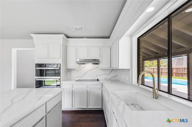 a kitchen with white cabinets and white appliances