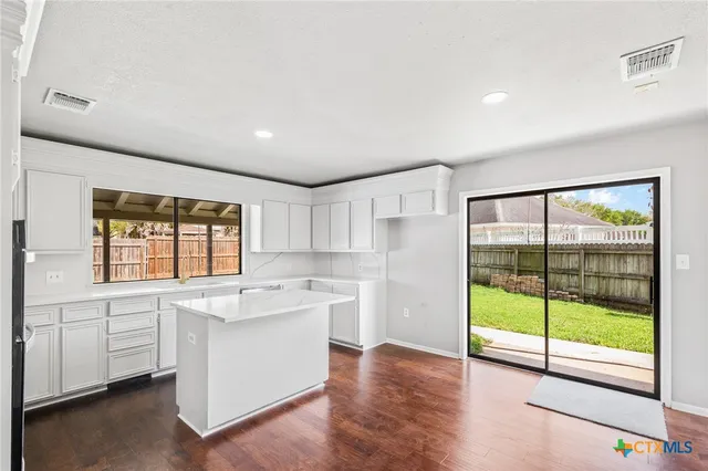 a view of a kitchen with a sink and dishwasher with wooden floor
