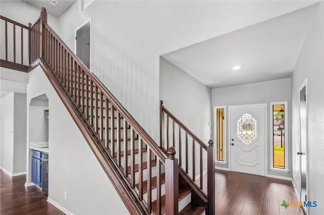 a view of staircase with lots of frames on wall and a window