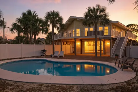 a view of swimming pool with palm trees