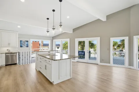 a kitchen with stainless steel appliances granite countertop a lot of counter space and wooden floors
