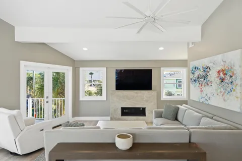 a living room with furniture a flat screen tv and a fireplace