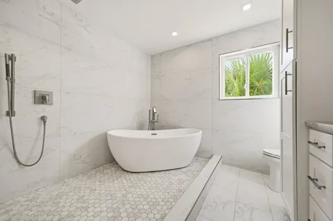 a bathroom with a toilet a sink a vanity and mirror