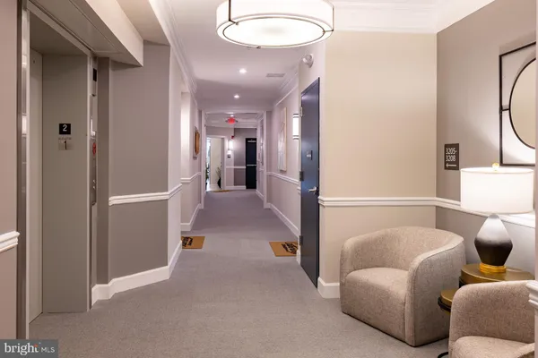a living room with furniture and a hallway