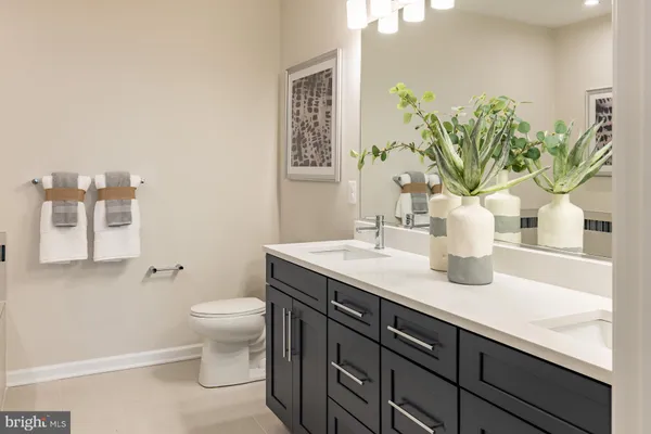 a bathroom with a granite countertop sink a toilet and a large mirror