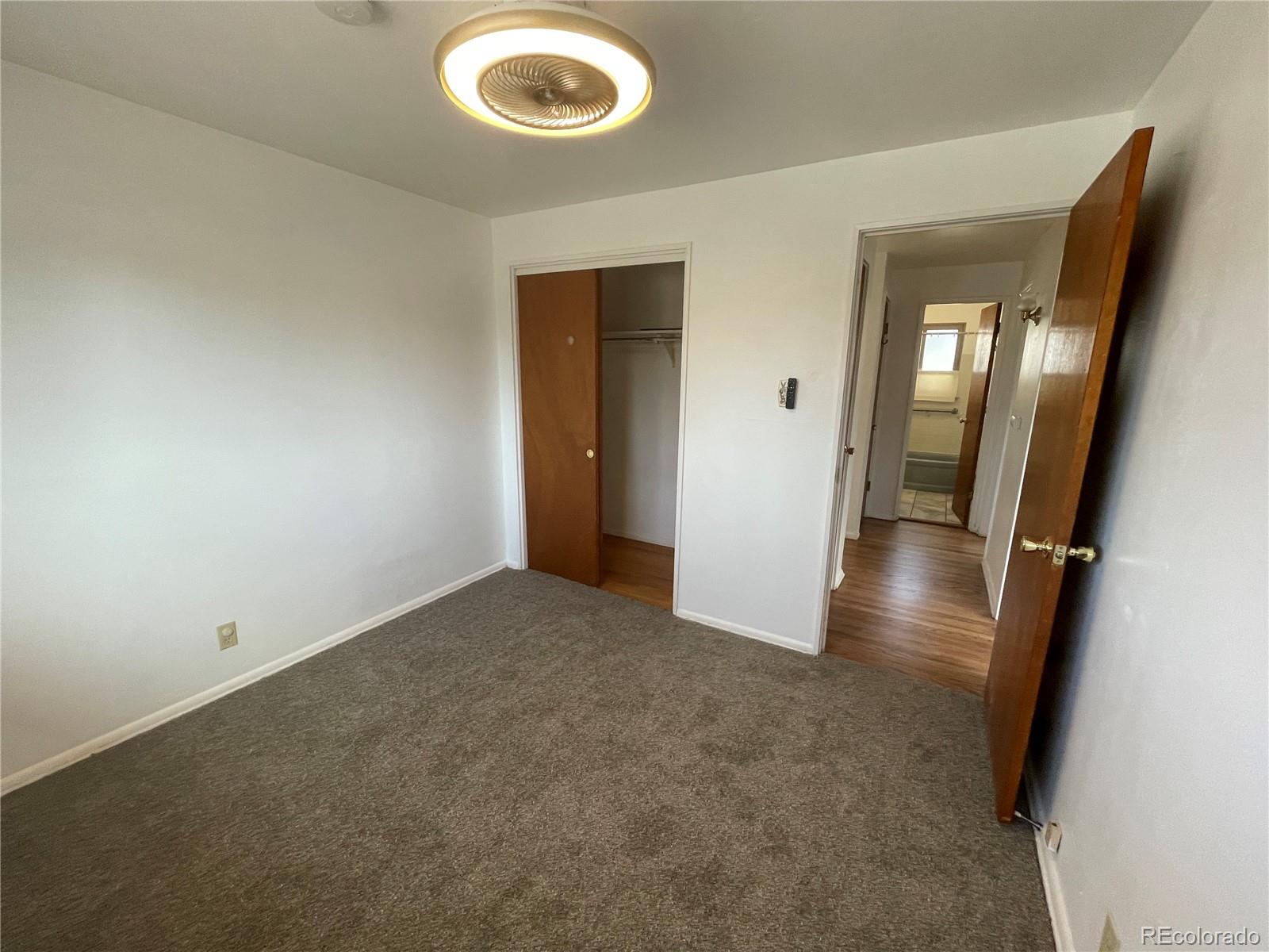 3086 Victor Street Aurora, CO 80011 - Photo 14 of 30 an empty room with wooden floor and mirror