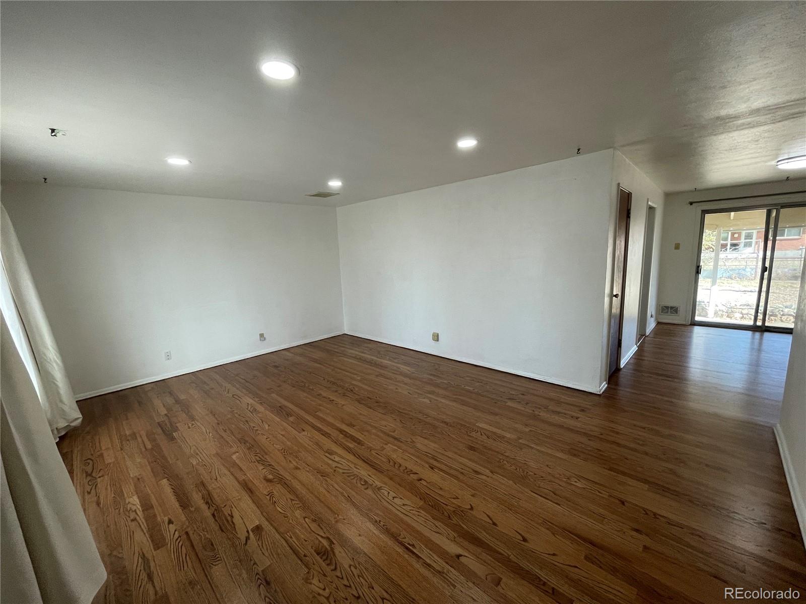 3086 Victor Street Aurora, CO 80011 - Photo 3 of 30 an empty room with wooden floor and windows