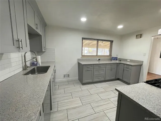 a kitchen with stainless steel appliances granite countertop a sink stove and cabinets