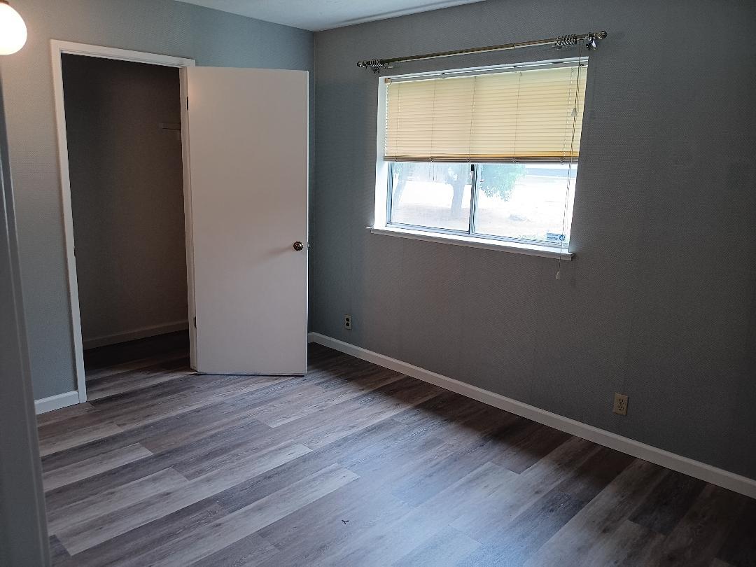 19324 Farallon Road Madera, CA 93638 - Photo 7 of 10 an empty room with wooden floor and windows