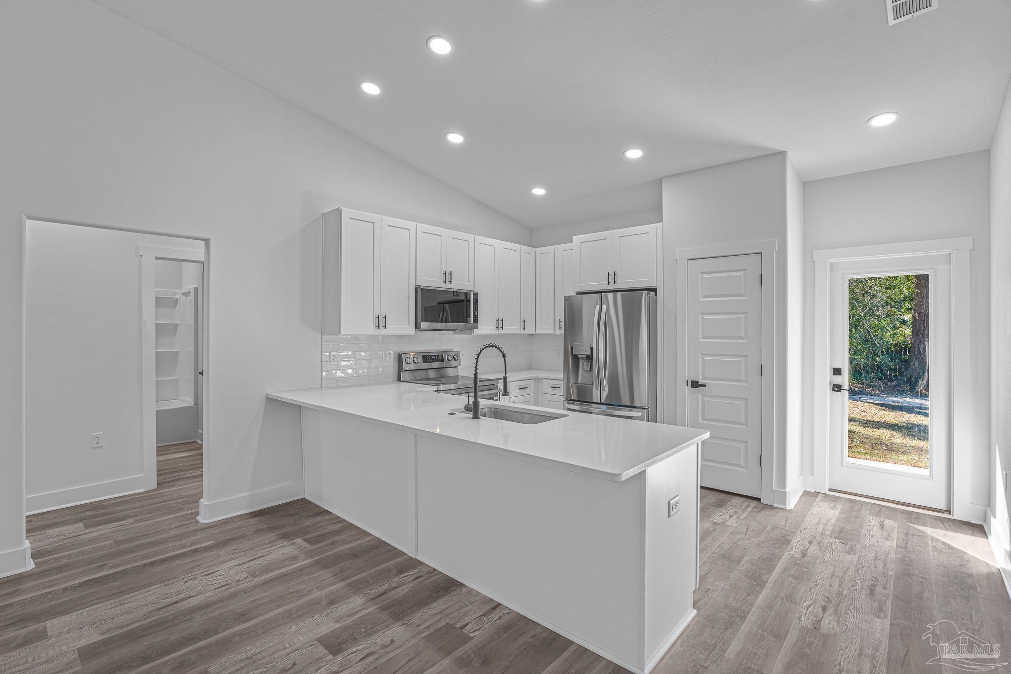 5005 Saufley Field Road Pensacola, FL 32526 - Photo 21 of 27 a large kitchen with kitchen island a sink stainless steel appliances and cabinets