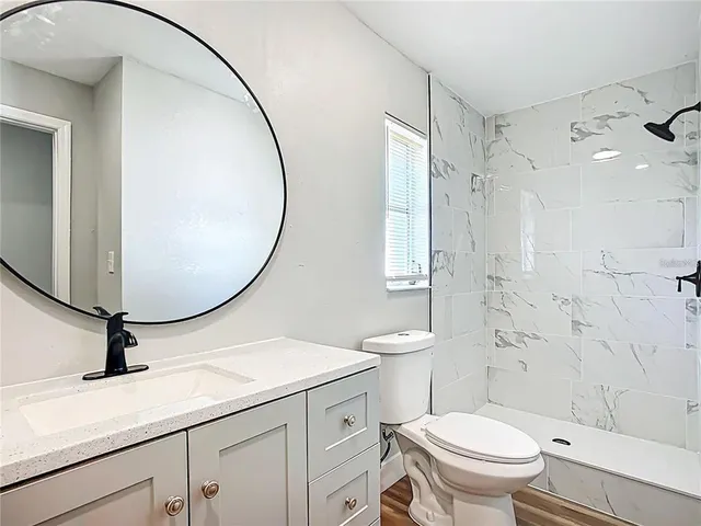 a bathroom with a sink a toilet and a mirror