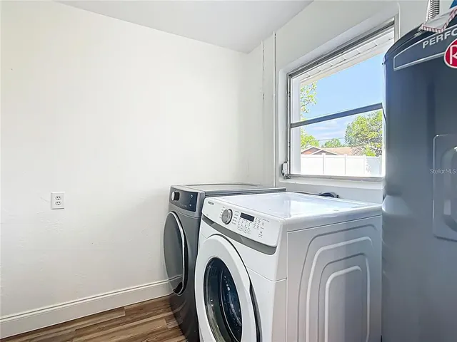 a view of washer and dryer with bathroom in the background