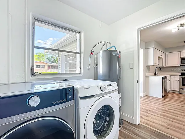 a view of washer and dryer with bathroom in the background