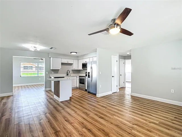 a kitchen with kitchen island white cabinets and stainless steel appliances