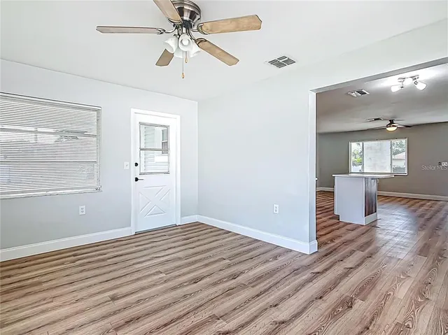 a view of empty room with wooden floor