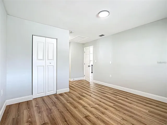 a view of an empty room with wooden floor