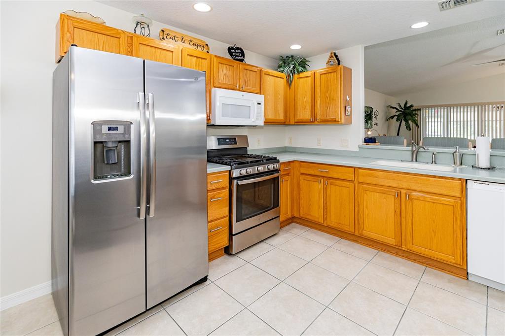 15858 Southwest 11th Court Road Ocala, FL 34473 - Photo 16 of 59 a kitchen with stainless steel appliances granite countertop a refrigerator a sink a stove and white cabinets