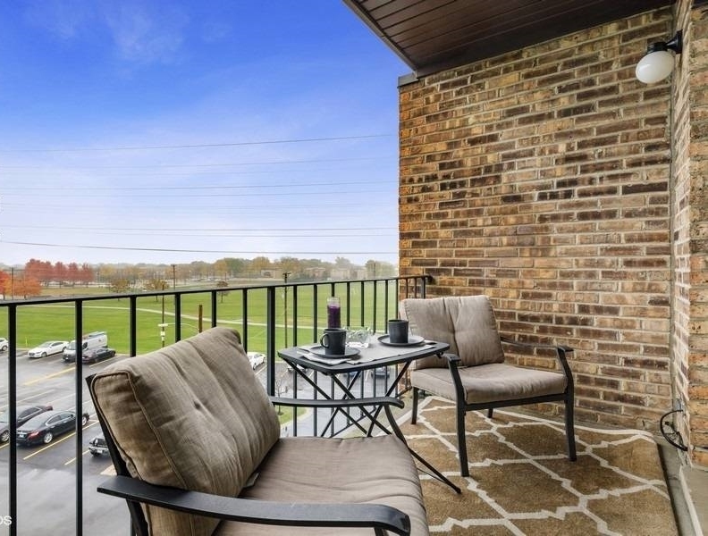 725 West Huntington Commons Road, Unit 416 Mount Prospect, IL 60056 - Photo 14 of 17 a balcony with a table and chairs