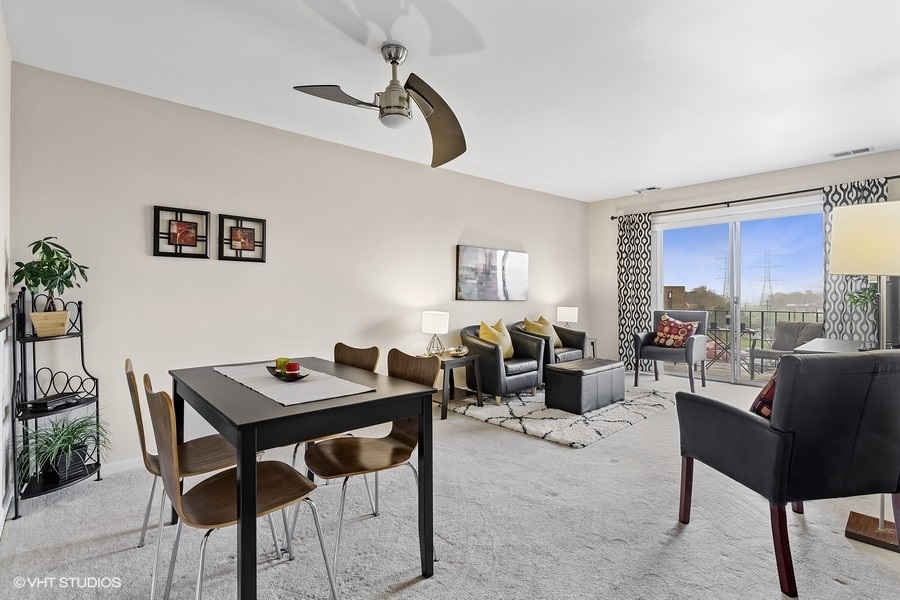725 West Huntington Commons Road, Unit 416 Mount Prospect, IL 60056 - Photo 4 of 17 a living room with furniture and a table