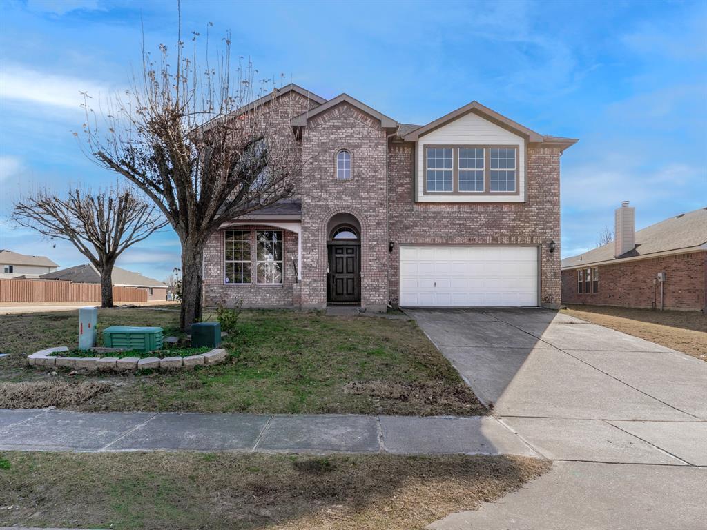 Traditional-style house with brick siding, concrete driveway, and an attached garage