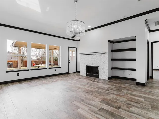 a view of an empty room with a fireplace and a window