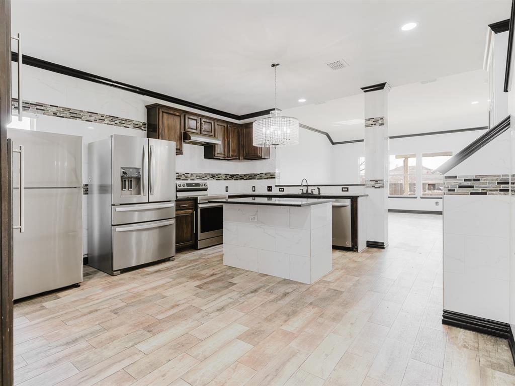 1733 Elm Street Anna, TX 75409 - Photo 5 of 25 a kitchen with stainless steel appliances granite countertop a stove top oven and refrigerator