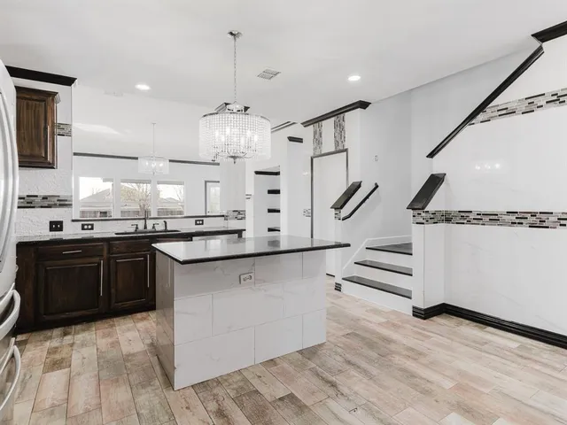a kitchen with stainless steel appliances kitchen island granite countertop a sink and cabinets
