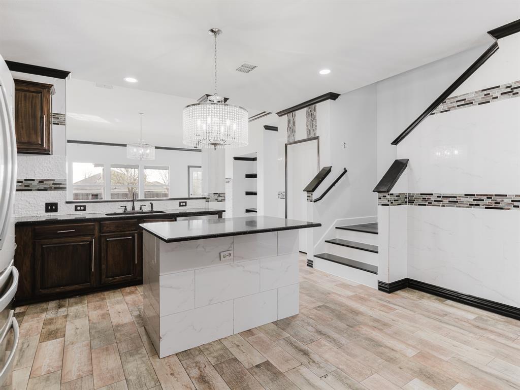 1733 Elm Street Anna, TX 75409 - Photo 6 of 25 a kitchen with stainless steel appliances kitchen island granite countertop a sink and cabinets