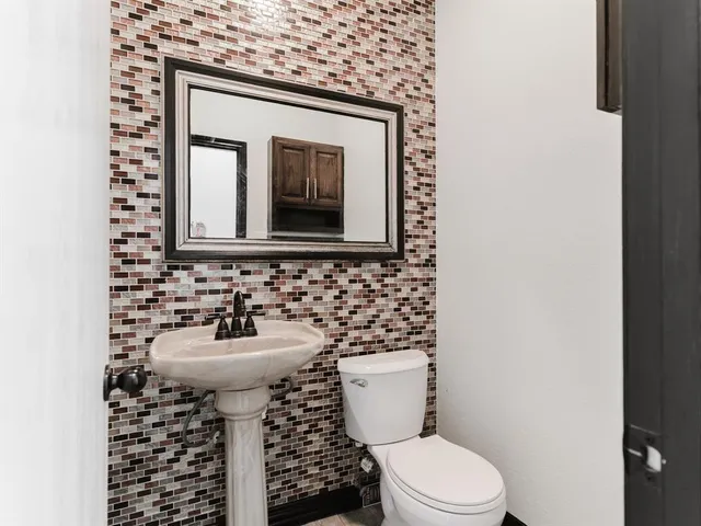 a bathroom with a toilet sink and mirror