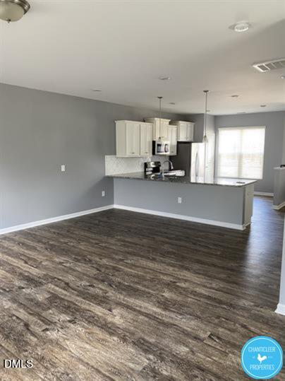 8960 Commons Townes Drive Raleigh, NC 27616 - Photo 4 of 13 a view of kitchen and empty room with wooden floor