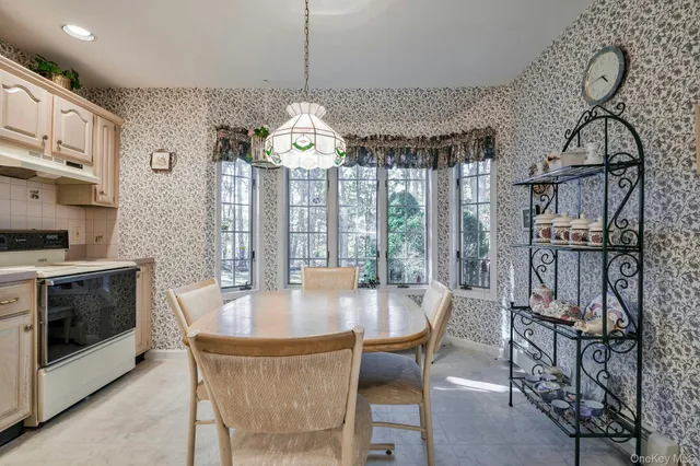 a front view of a house with a yard and large tree