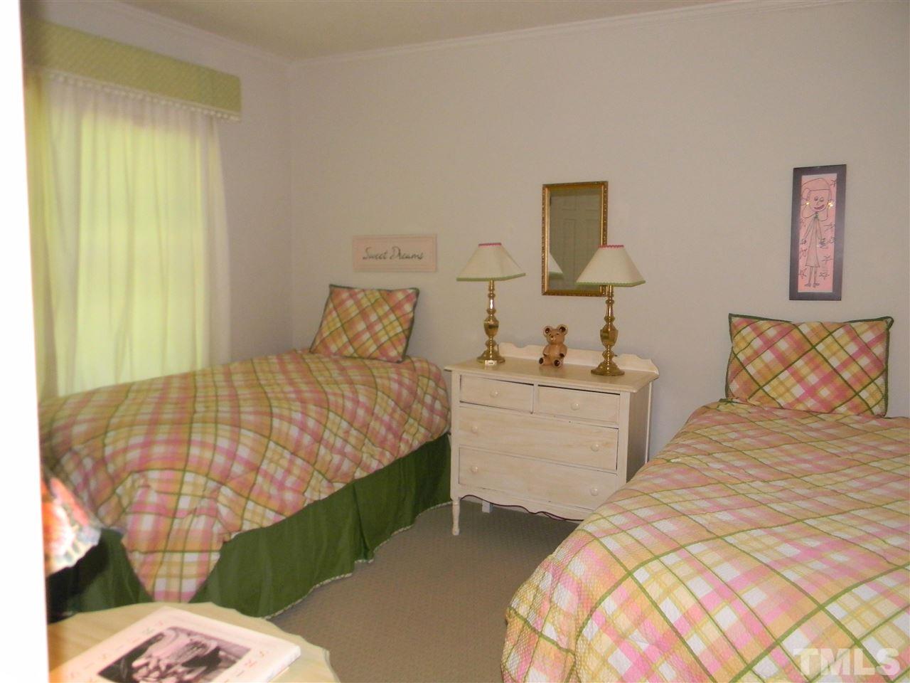 7919 Harps Mill Road Raleigh, NC 27615 - Photo 14 of 29 a bedroom with a bed and wooden floor