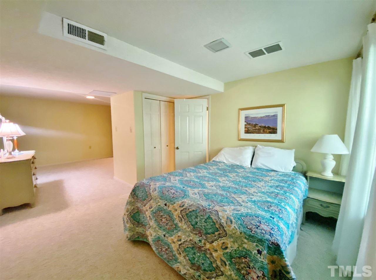 7919 Harps Mill Road Raleigh, NC 27615 - Photo 25 of 29 a spacious bedroom with a bed and a dresser