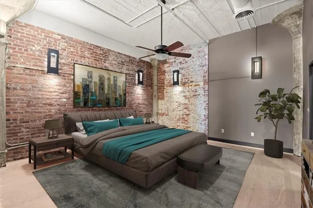 a bedroom with a bed a couch and potted plant