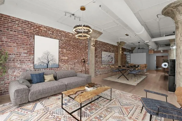 a living room with furniture a dining table and a chandelier