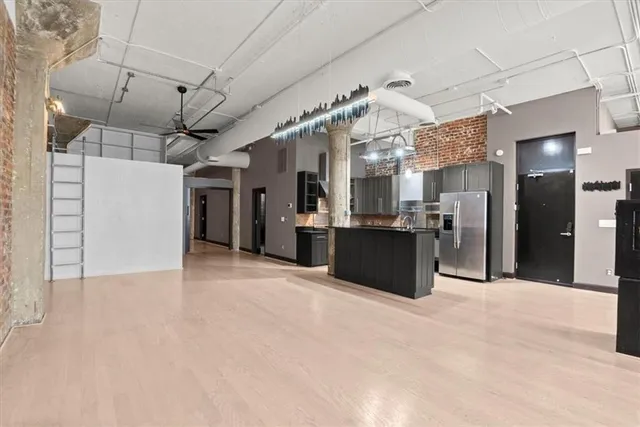 a large kitchen with stainless steel appliances kitchen island granite countertop a refrigerator and a sink