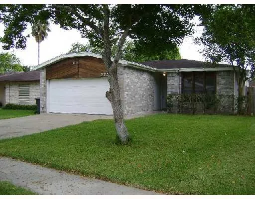 a view of a yard in front of a house with a large tree