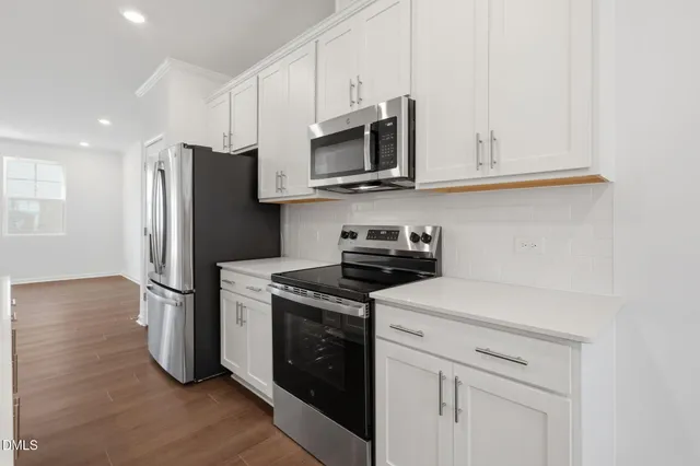 a kitchen with stainless steel appliances granite countertop a refrigerator and a stove top oven